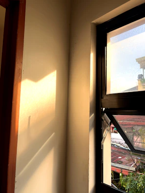 Sunlight streaming through a window, casting shadows over a digital drawing tablet.