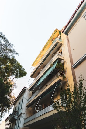 Exterior view of the 10-story residential building in Kipé with balconies and surrounding greenery.