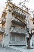 Exterior shot of a residential building with balconies and greenery.
