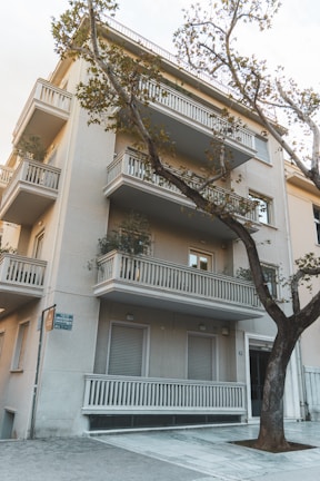 Exterior shot of a residential building with balconies and greenery.