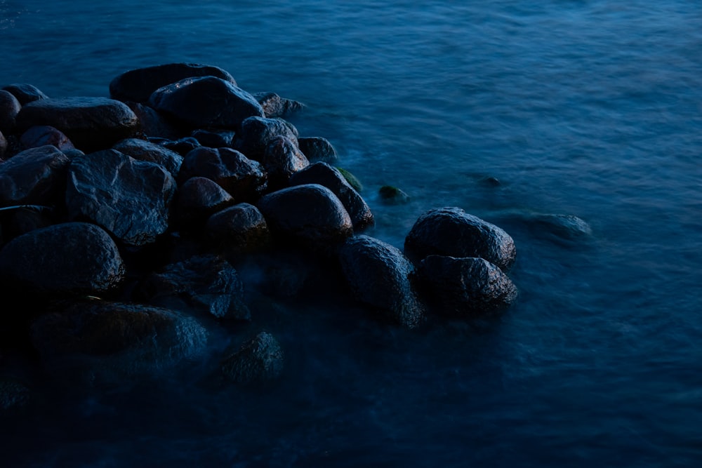 a group of rocks sitting on top of a body of water