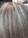 A close-up view of human hair with shades of brown and gray, showcasing the texture and mix of colors in the strands.