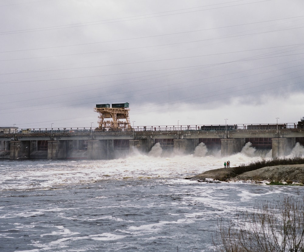 a large body of water with a bridge in the background