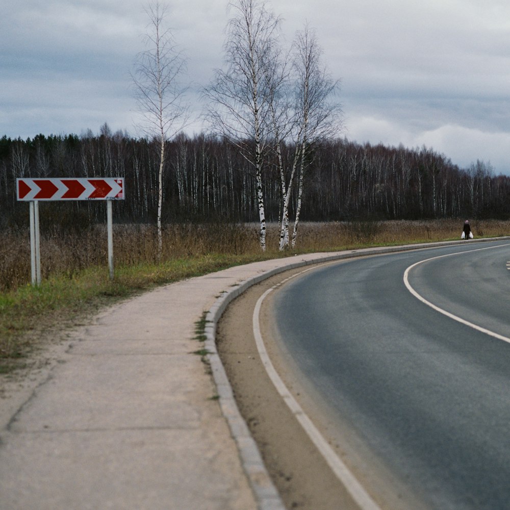 a curved road with a sign on the side of it