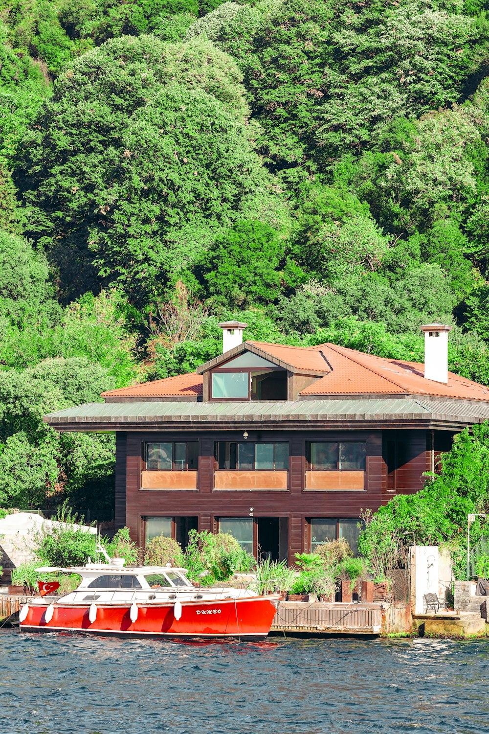 a house on the water with a boat in front of it