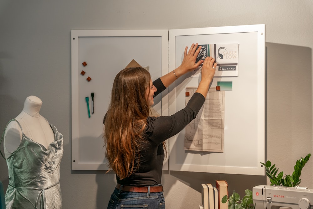 a woman is working on a project on a wall