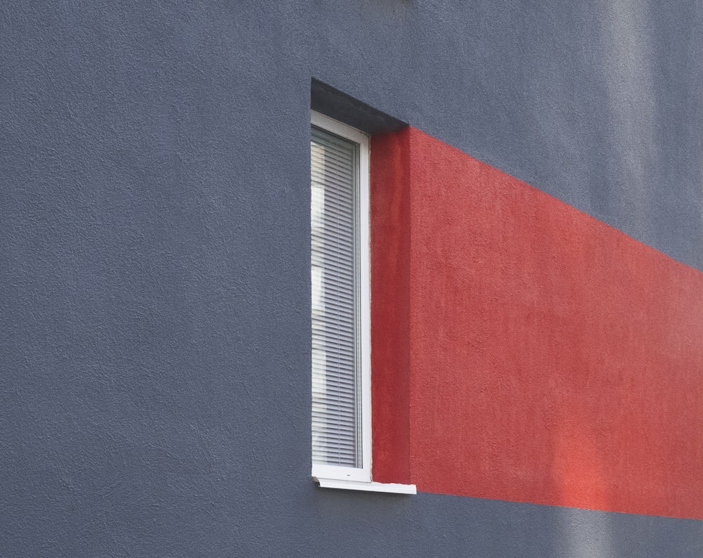 a red and blue building with a white window