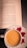 A book open to a page titled 'Build a Powerful Morning Routine' is situated on a table beside a white cup filled with a frothy beverage, likely coffee or tea, on a saucer. Beside the cup, there are two autumn leaves, providing a seasonal touch to the scene.