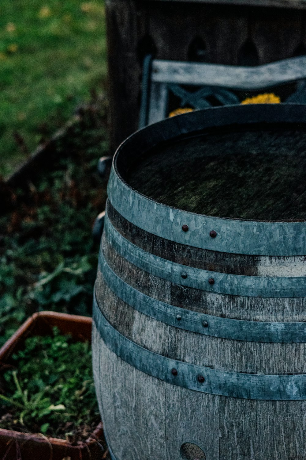 a wooden barrel sitting on top of a lush green field