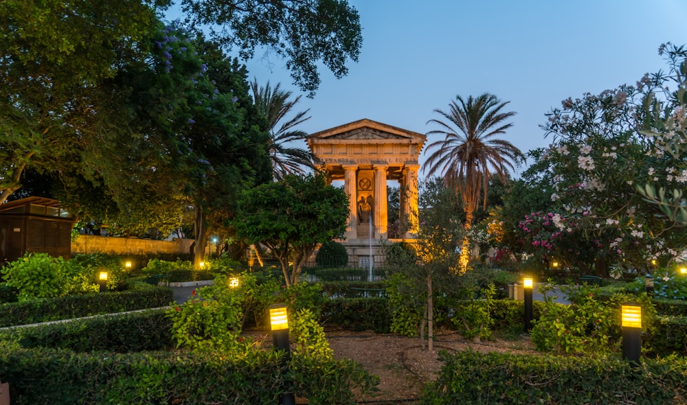 a gazebo surrounded by trees and bushes at night