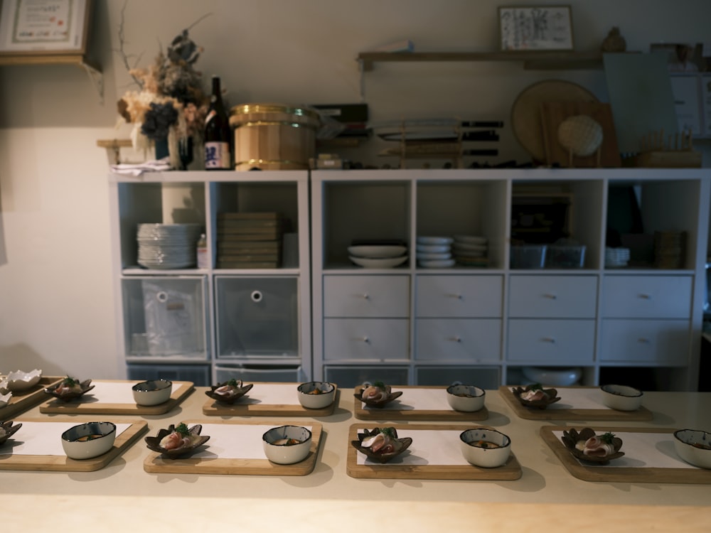 a table topped with bowls of food on top of wooden trays