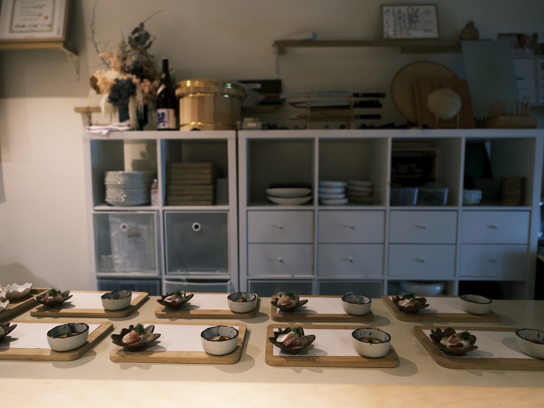 a table topped with bowls of food on top of wooden trays,