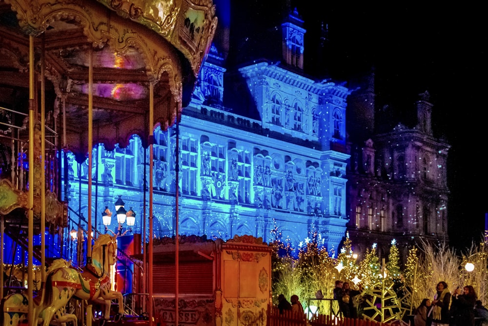 a merry go round at night with people walking around