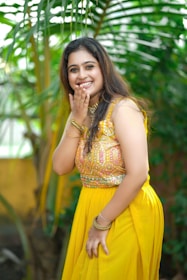 A cheerful woman wearing a bright ethnic kurti paired with casual jeans, smiling outdoors.