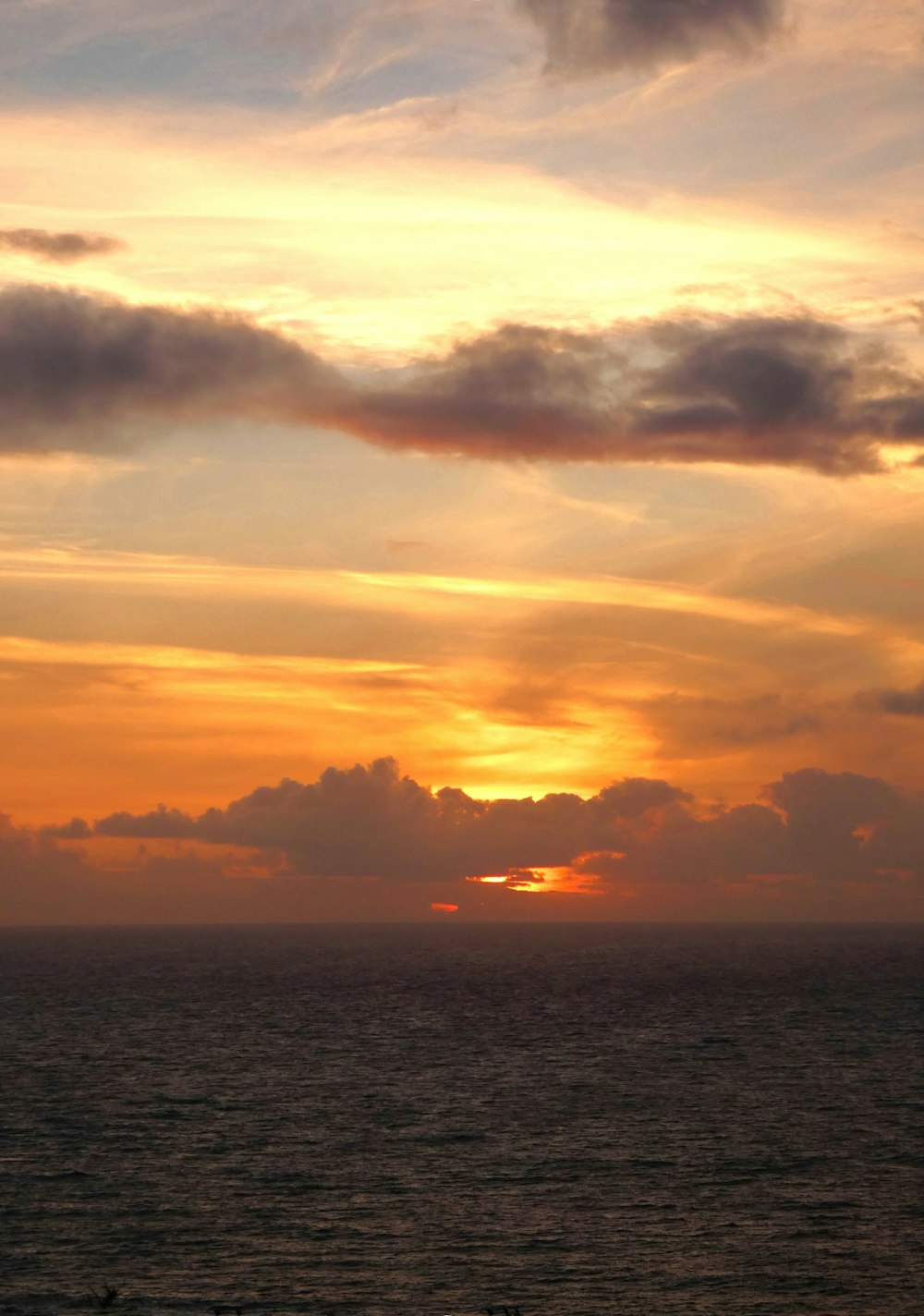 a large body of water with a sunset in the background