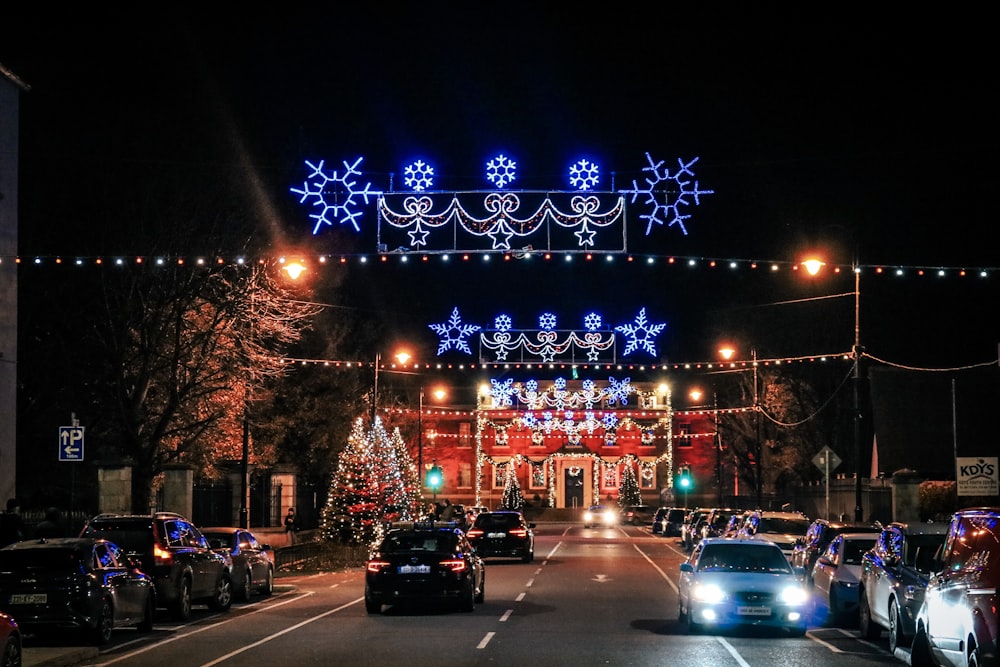 a street filled with lots of traffic next to a christmas light display