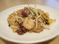 A vibrant stir-fry of fresh vegetables and succulent shrimp, sizzling on a hot plate.