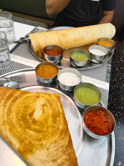 A vibrant bowl of spicy masala dosa with coconut chutney on the side.