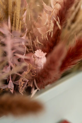 Styled pampas and dried flowers displayed on a white mantel with subtle shadows.
