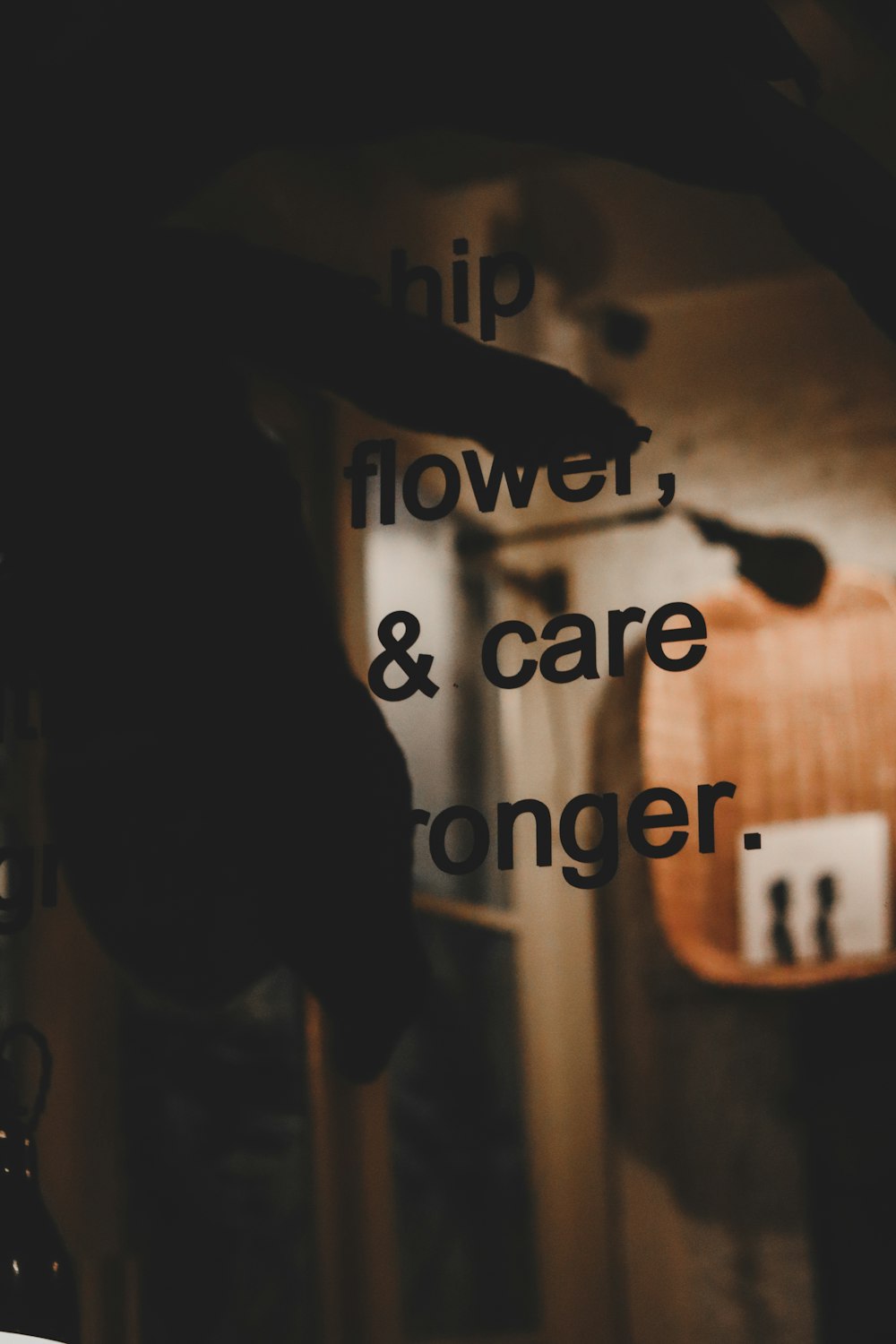 a black and white photo of a person pointing at a sign