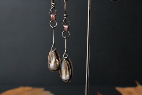 a pair of earrings hanging from a hook