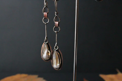 Sophisticated earrings hanging on a minimalist white stand with soft shadows