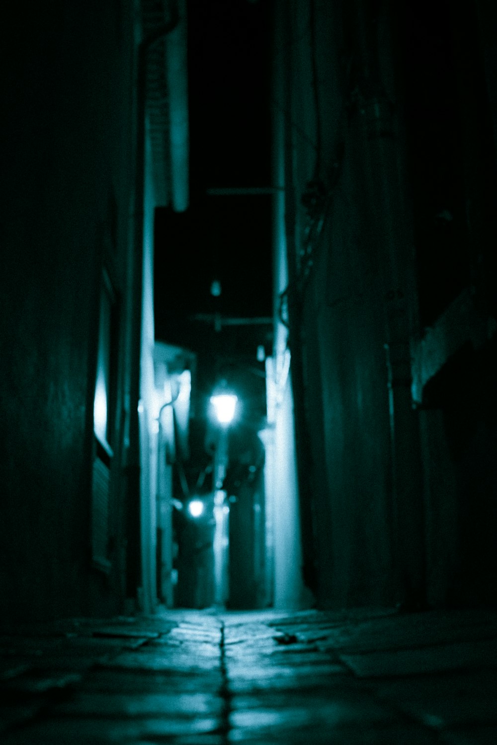 a dark alley way with a light at the end
