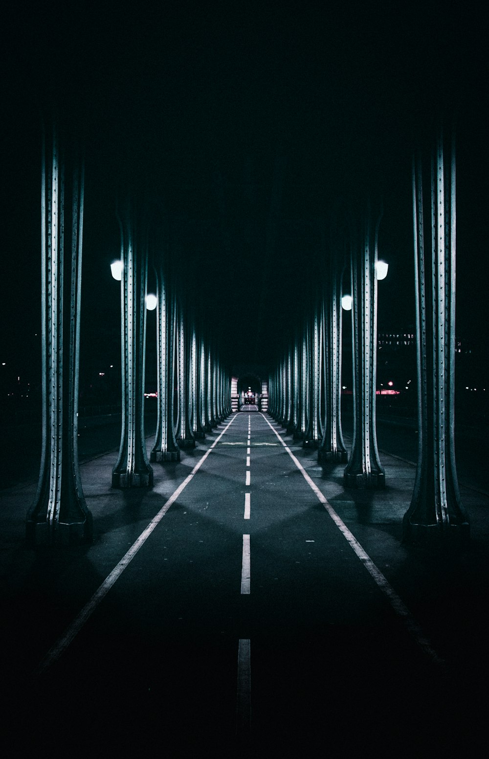 a dark street with a long line of street lamps