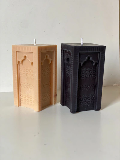 Various geometric-shaped candles arranged on a wooden table, highlighting their smooth finishes.