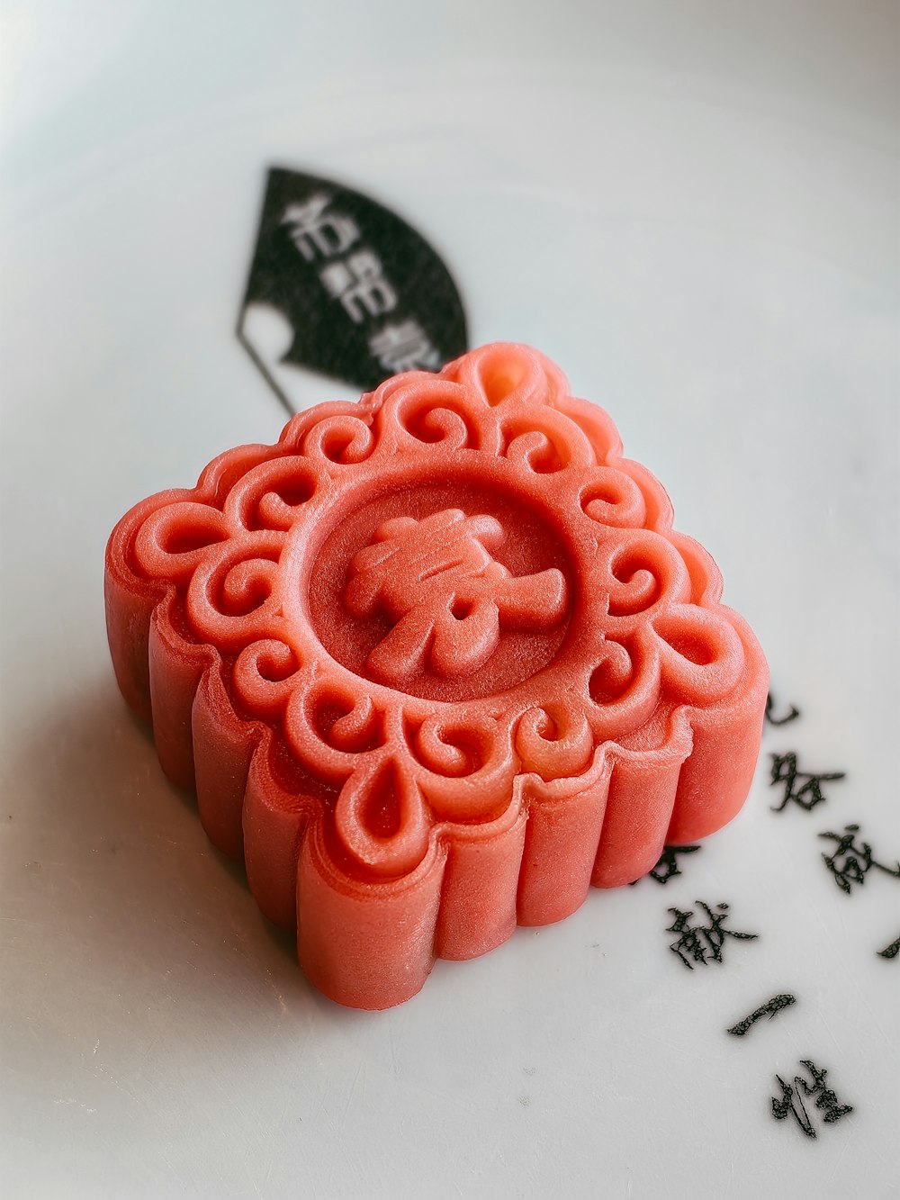 a red wax stamp sitting on top of a white plate