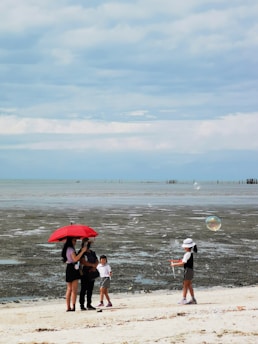 A family smiling together under an umbrella symbolizing protection and security.