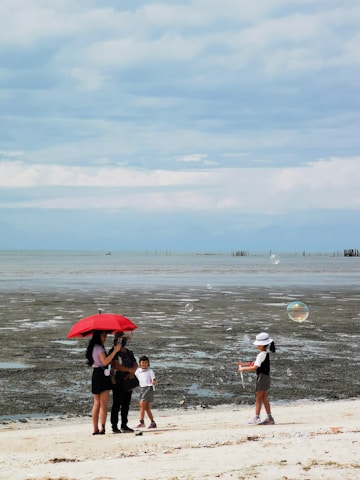 A joyful family enjoying a sunny beach vacation with bright umbrellas.