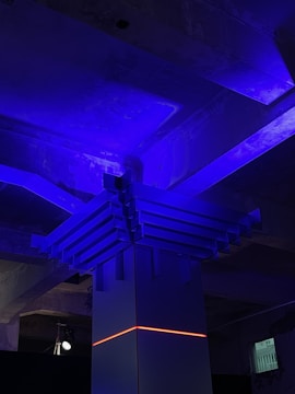 Spacious living room with dark blue walls and neon light accents.