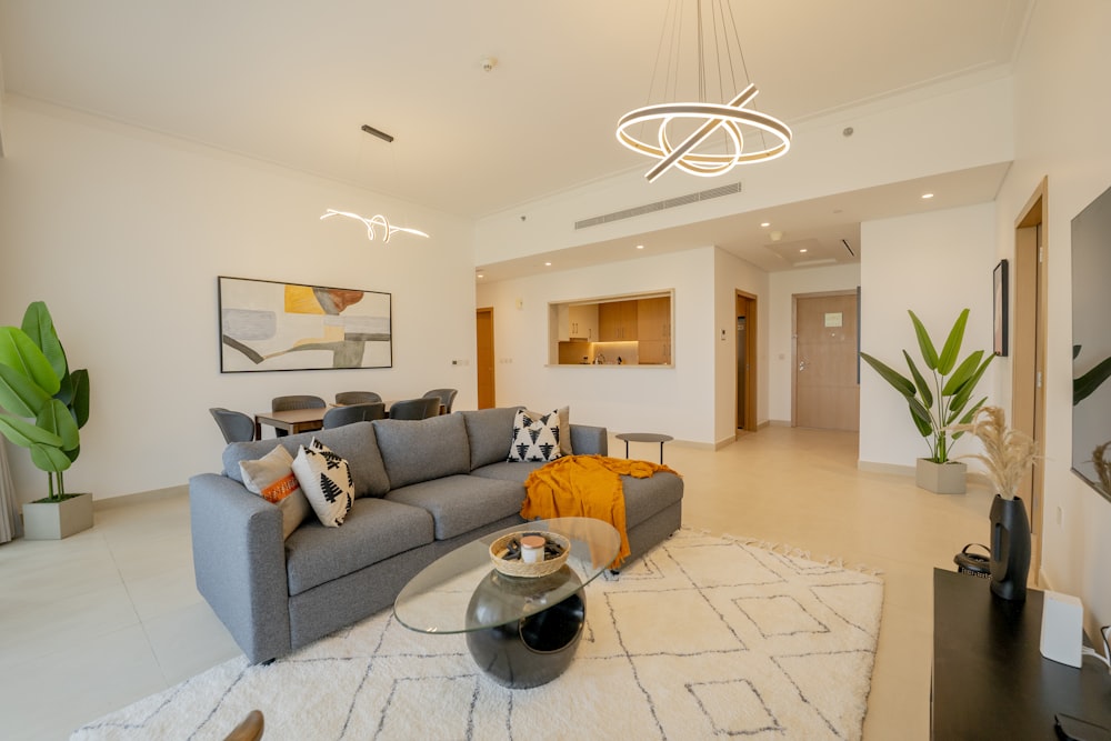 a living room with a gray couch and a white rug