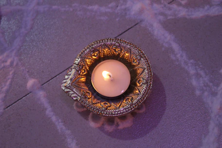 Close-up of a brass candle holder with intricate floral engravings glowing softly in warm light