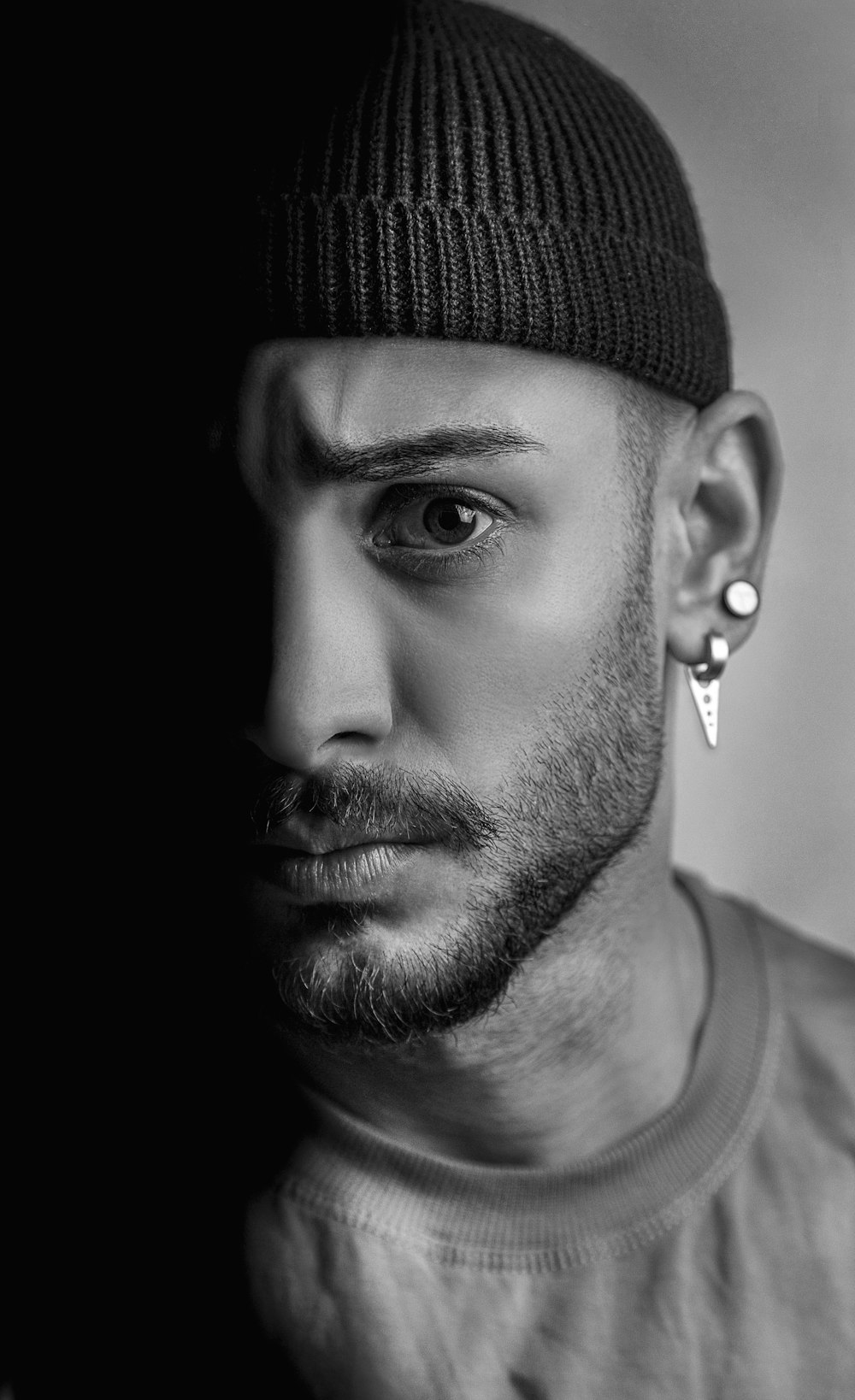 a black and white photo of a man wearing a beanie