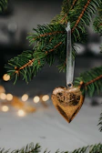 a wooden heart ornament hanging from a christmas tree