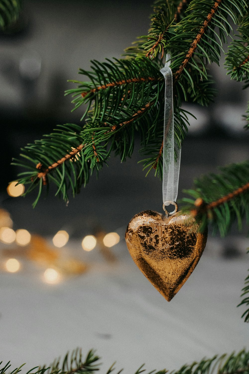 a wooden heart ornament hanging from a christmas tree