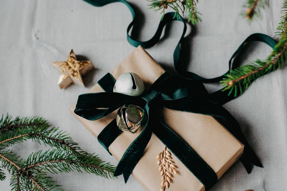 a present wrapped in a green ribbon with a bell on it