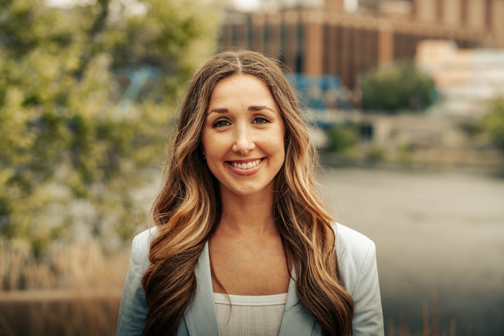 a woman with long brown hair smiling at the camera