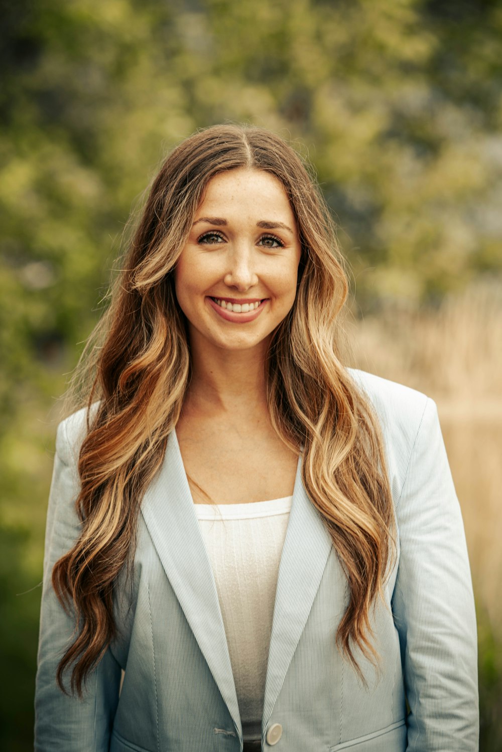 a woman with long hair wearing a blue blazer