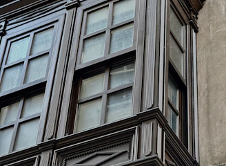 A craftsman fitting new trim around a window with neat, clean lines.