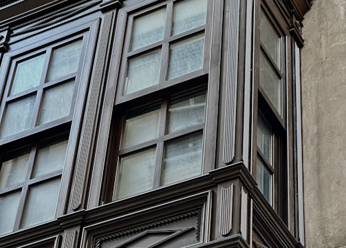 A craftsman fitting new trim around a window with neat, clean lines.