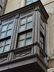 Close-up of a craftsman carefully installing elegant wooden trim around a window.