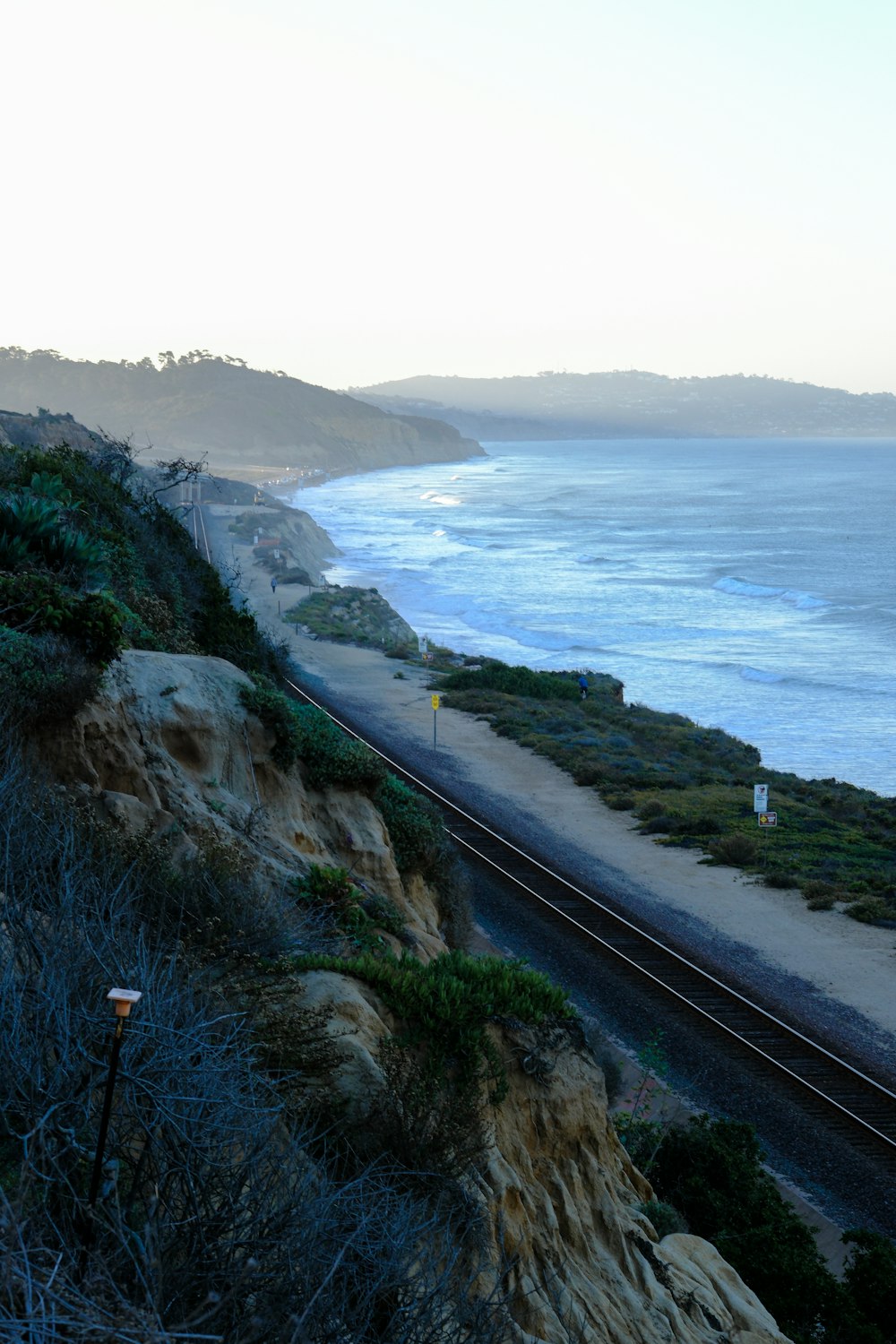 a view of a train track next to the ocean