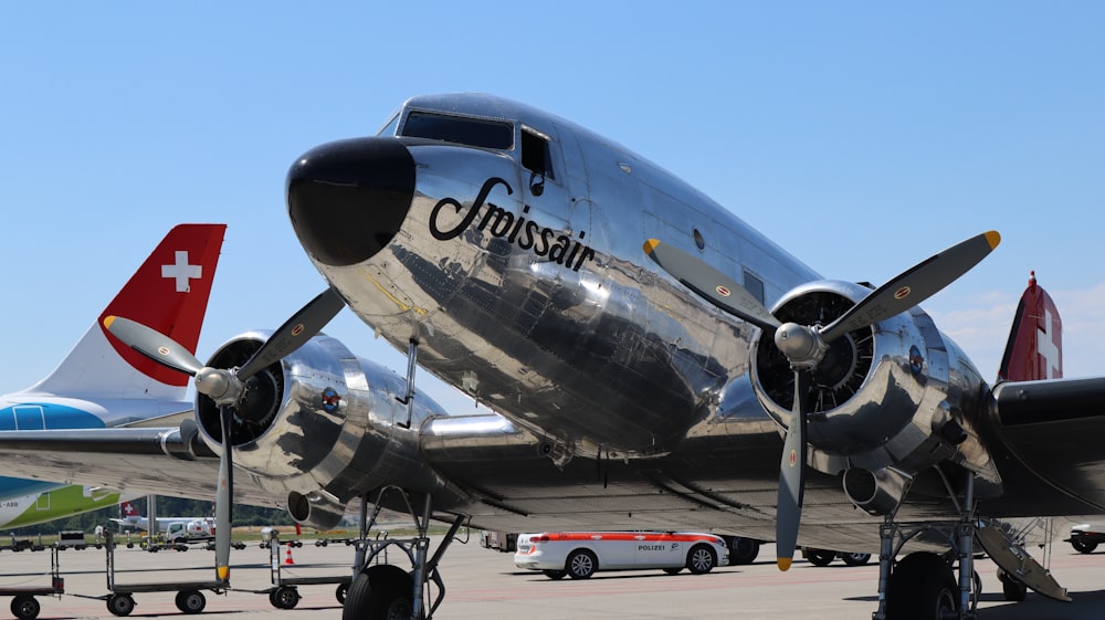 Ein großes silbernes Flugzeug sitzt auf dem Rollfeld eines Flughafens