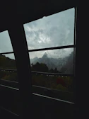 Panoramic view of mountain peaks framed by large windows.
