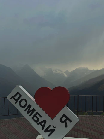 A smiling tour guide welcoming travelers against a backdrop of Romania’s Carpathian Mountains.