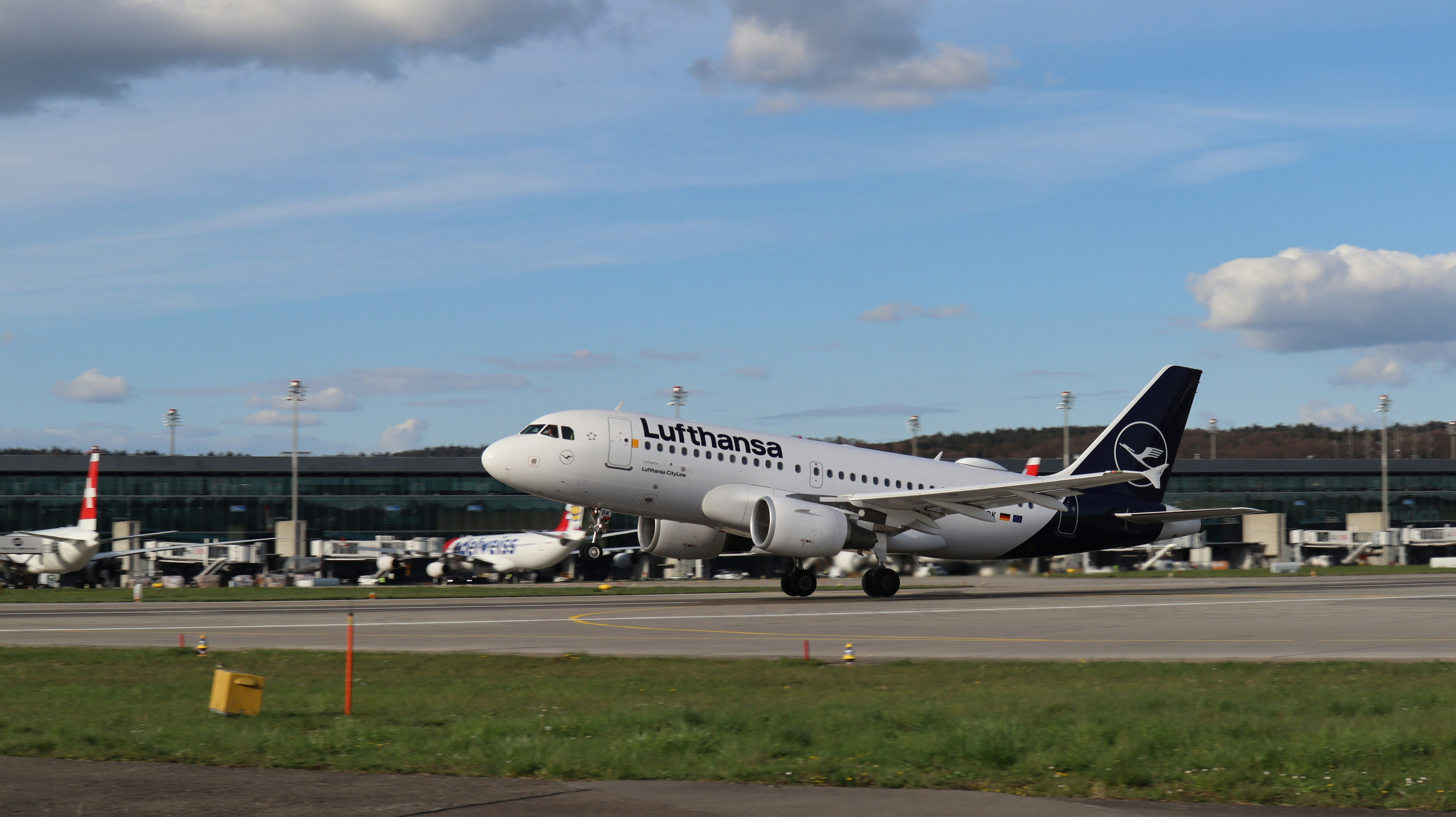 a large jetliner sitting on top of an airport runway, Lufthansa arriving at Zurich Airport.