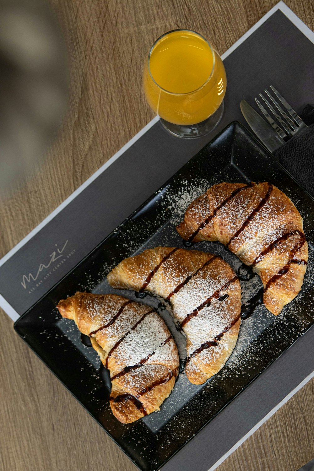 a tray of pastries and a glass of orange juice